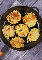 Potato Pancakes. Vegetable fritters. Latkes in frying pan. View from above, top studio shot
