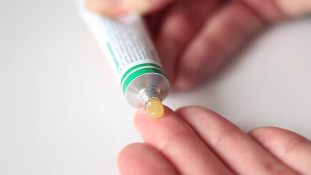 Somebody squeezing out an ointment