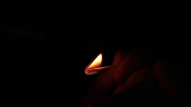 Man with a cigarette getting a light in darkness