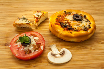 Mini vegetarian pizza with mushrooms olives and tomato