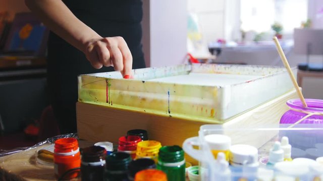 Process of painting - woman draws on water in Liquid Ebru art technics - list of paper
