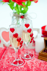 Два бокала влюбленной пары с шампанским и сердцами