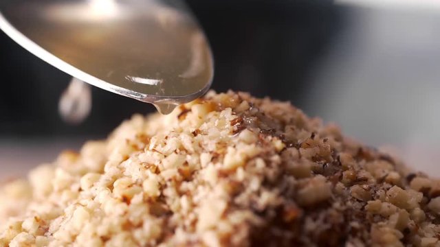 Making the dish in macro, cook adds sauce to the meal, food in slow motion