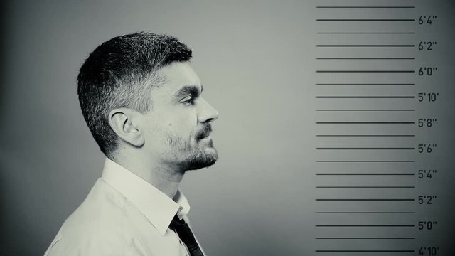 Mugshot of prisoner, male criminal getting photographed at police station