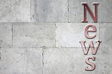 News carved on white stone wall