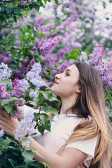 Fototapeta premium Beautiful woman smelling a lilac