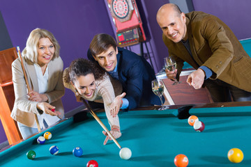 Relaxed people playing billiard and darts