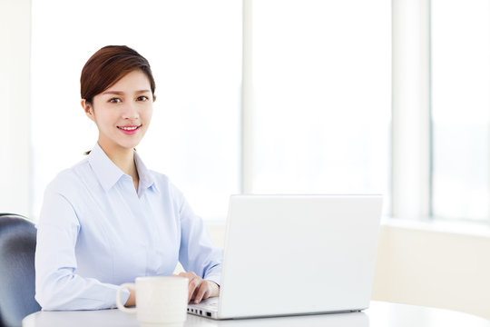Young  business woman with laptop in the office
