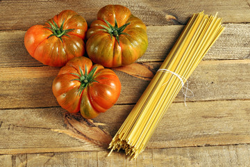 Spaghetti and natural tomatoes on wood background