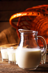 Goat milk in glasses, vintage wooden background, selective focus
