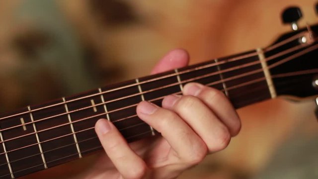 Fingers playing on the guitar's  neck