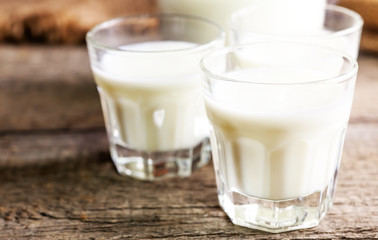 Goat milk in glasses, vintage wooden background, selective focus