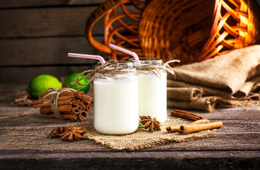 Fresh dairy products and cinnamon on an old wooden background, selective focus