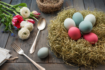 Still life with easter eggs in a nest and flowers