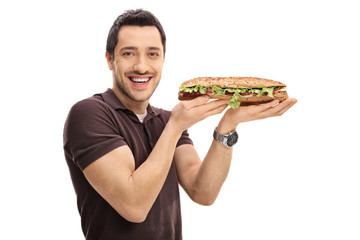 Happy guy holding a sandwich and looking at the camera - Powered by Adobe