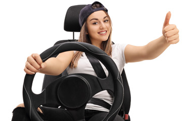 Teenage girl in car seat and making thumb up sign
