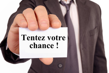 Homme tenant une carte avec tentez votre chance écrit dessus 