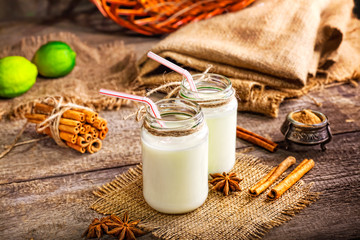 Fresh dairy products and cinnamon on an old wooden background, selective focus