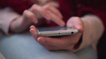 Girl surfing the Internet using smartphone. Close-up.