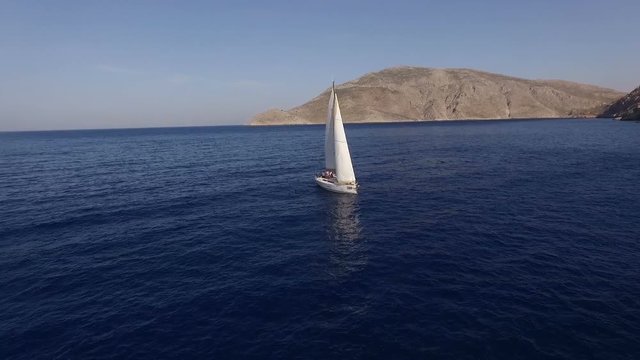 Sailing boat navigating in the sea with open sails