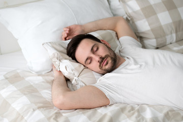 Obraz na płótnie Canvas Handsome male sleeping in bed
