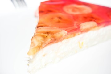 Cottage cheese cake with banana slices and gelatin on isolated background
