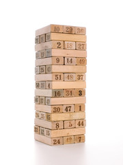 Blocks of game jenga isolated on white background. Vertical tower whole and in game. Wooden blocks in stack with figures digit on body.