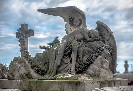 Sculpture of a sad angel on a cemetery