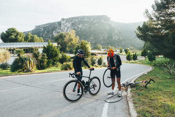 Two cyclists fixing a flat tire