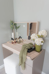 Fototapeta na wymiar Beauty and make-up concept: table mirror, flowers, perfume, jewelry and makeup brushes on wooden table