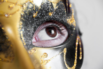 Beautiful brown eyes in a golden theatrical mask