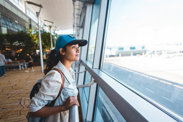 Young woman at airport waiting for airplane