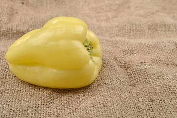 Sweet yellow pepper lying on jute canvas background. Concept of healthy food, bio from countryside