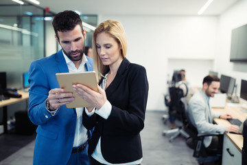 Business colleagues looking at tablet in office