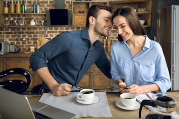 portrait of smiling couple having breakfast in kitchen