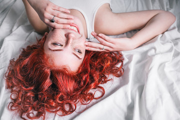 Portrait of young beautiful woman with long hair lying in the bed
