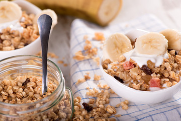 A bowl of muesli cereal, yoghurt and banana for breakfast