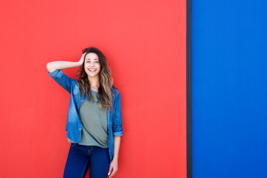 woman with hand in hair against blue and red background