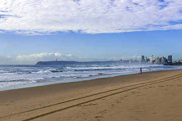 Sandy Beach Ocean and Waves Against City Skyline