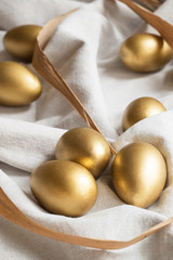 Ostereier aus Gold auf Leinen und Schilf