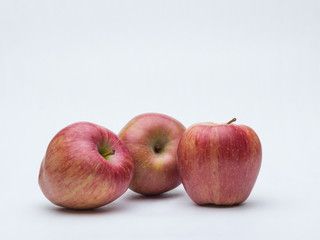 three red apples on white background