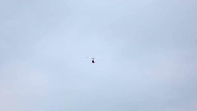 Red helicopter flying in the blue sky