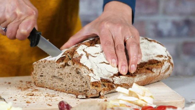 woman hands cuts a traditional bread slice