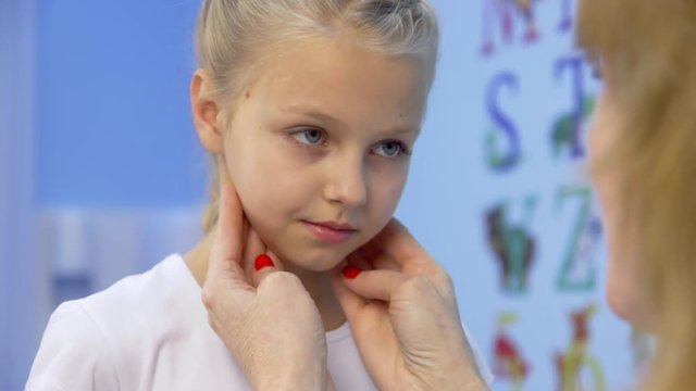 Doctor examining girl's neck