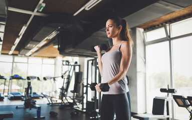 Sporty strong woman working out in gym