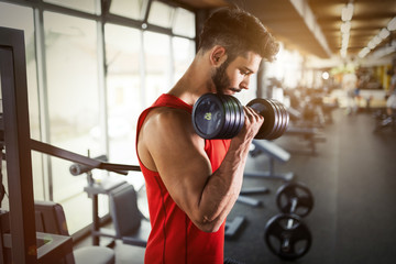Naklejka na ściany i meble Determined male working out in gym