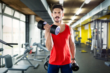 Fototapeta na wymiar Determined male working out in gym