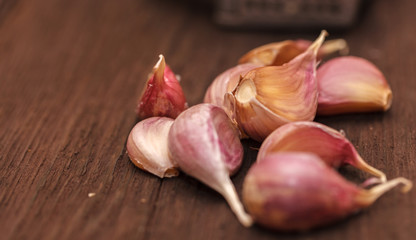 masher for garlic and garlic on a wooden background