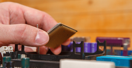 repairman inserted CPU into the socket on the motherboard. Close-up.