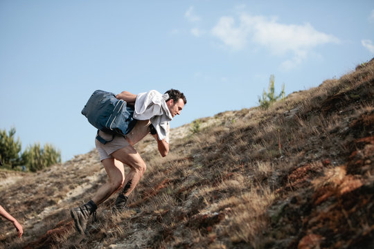 Man climbing up a desert hill